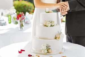 Newlywed Couple Cutting Cake During Reception
